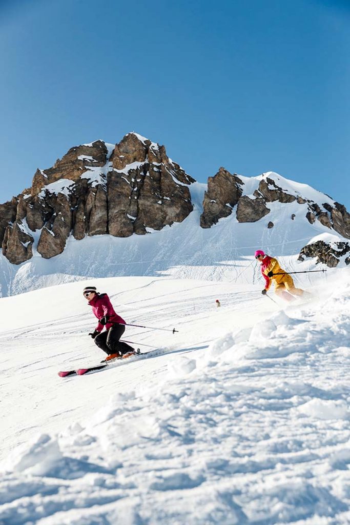 Deux skieuses profitant sereinnement de la neige fraiche en pleine station de Tignes.